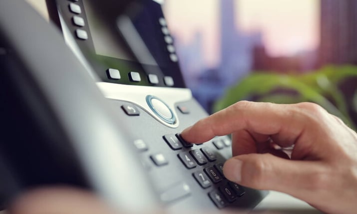 Dialing a number on a desk phone with GoTo Connect.