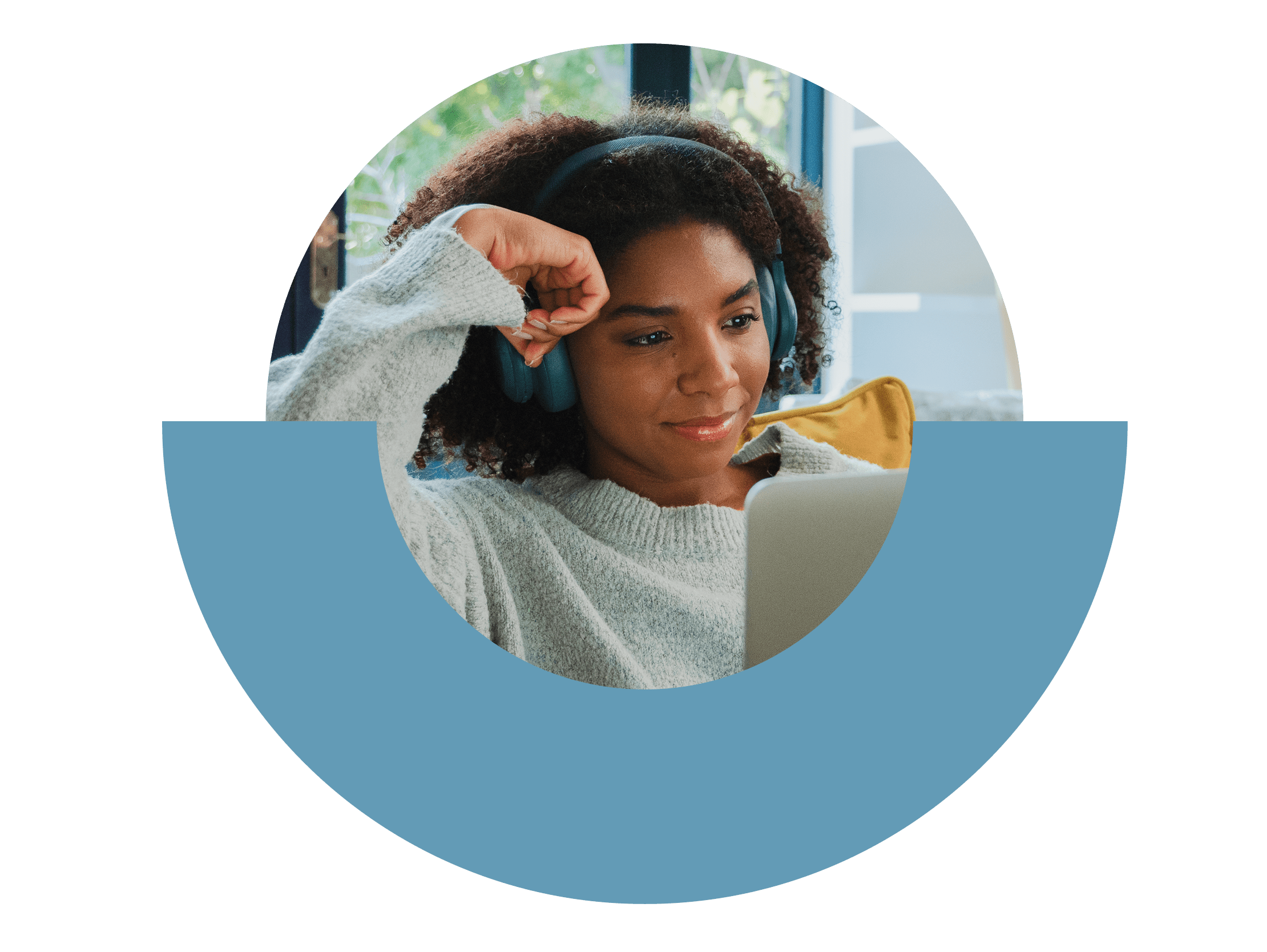 Person sitting back on couch with headphones on looking at laptop computer