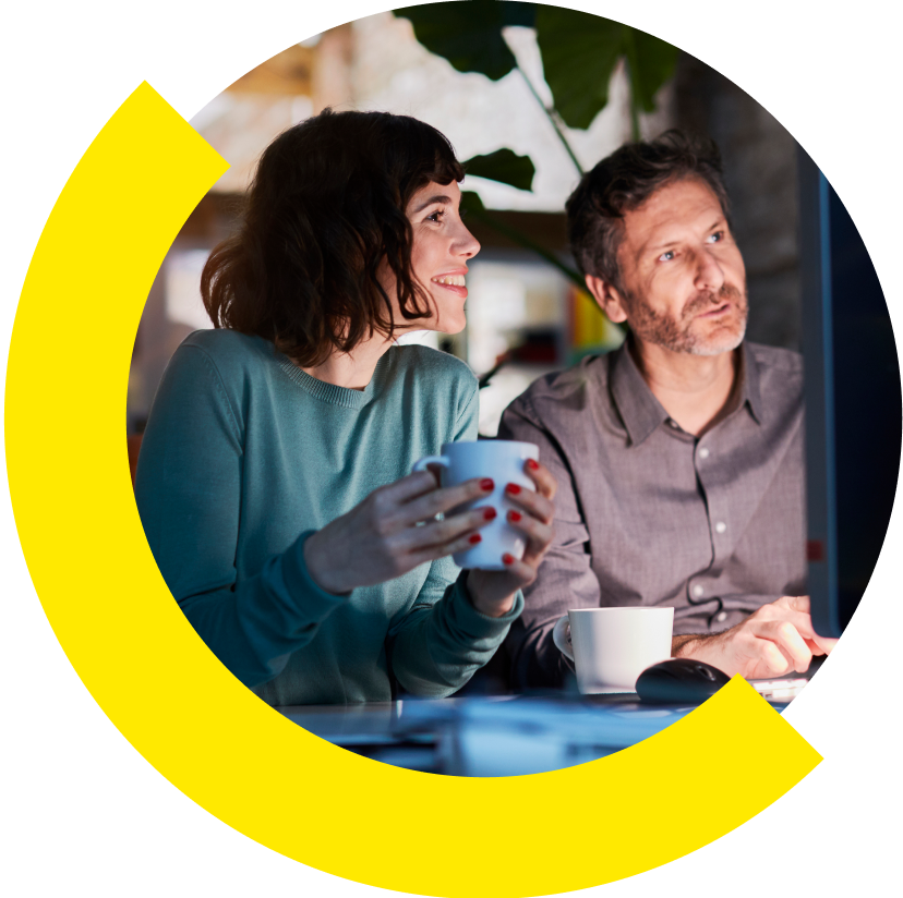 Two people smiling while looking at a computer together.
